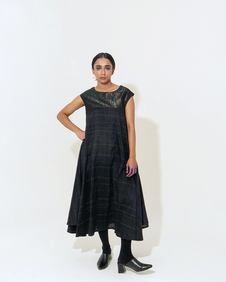 The Shoonyata Lunar Dress is a sleeveless garment with a relaxed silhouette that flows elegantly Made from handwoven silk using the traditional weaving technique.