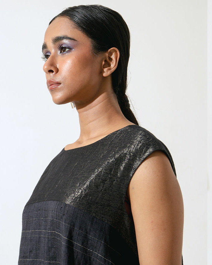 The Shoonyata Lunar Dress is a sleeveless garment with a relaxed silhouette that flows elegantly Made from handwoven silk using the traditional weaving technique.