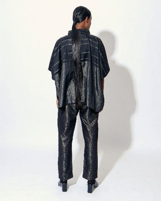 The Shoonyata Burnished Tissue Pants are crafted from silk tissue fabric with a subtle burnished finish, creating a soft shimmer. These relaxed-fit pants feature a gently tapered silhouette that combines comfort with contemporary style.